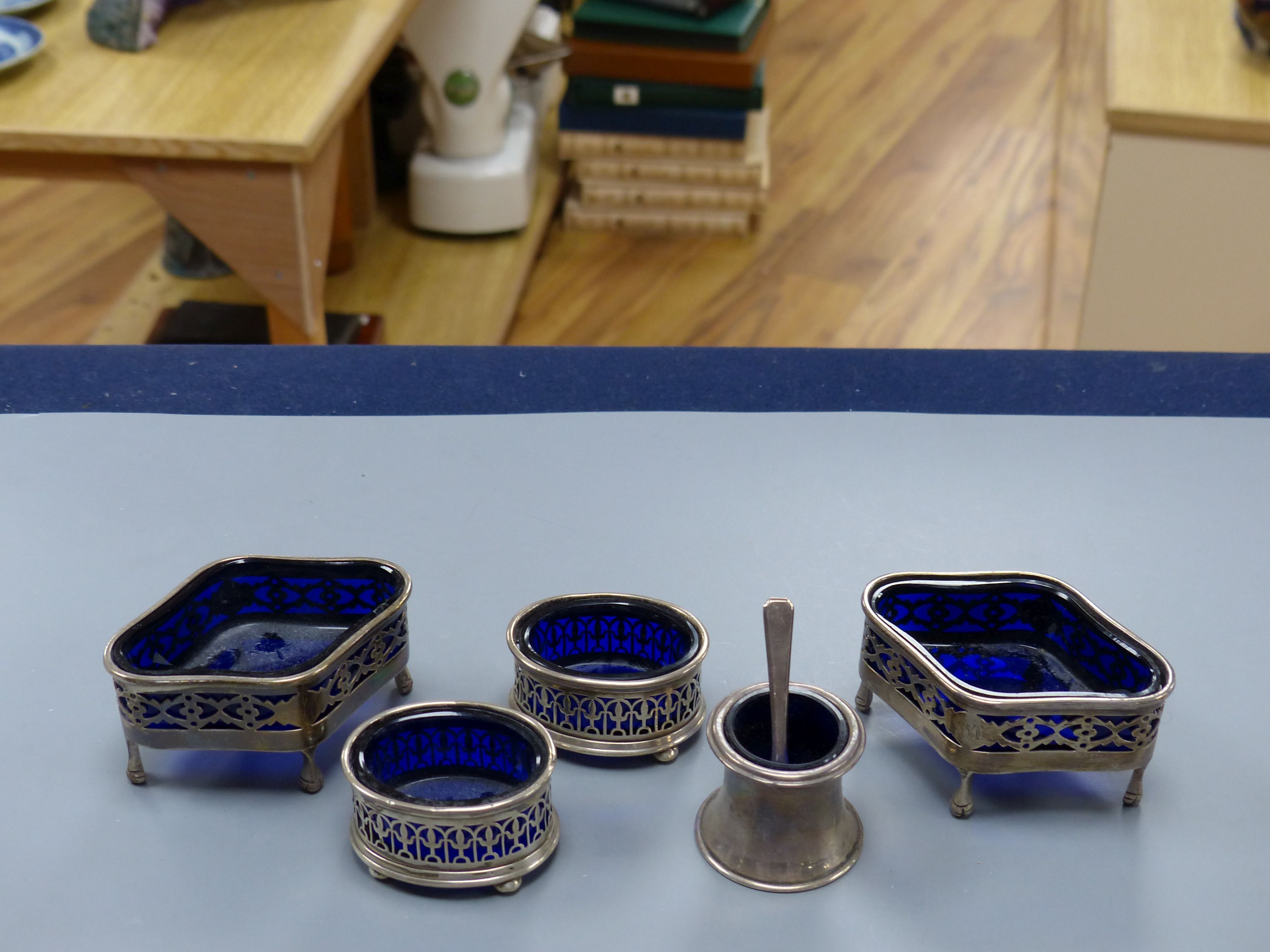 A pair of Edwardian pierced silver quatrefoil shaped salts with blue glass liners, London, 190987mm and three other smaller silver salts.